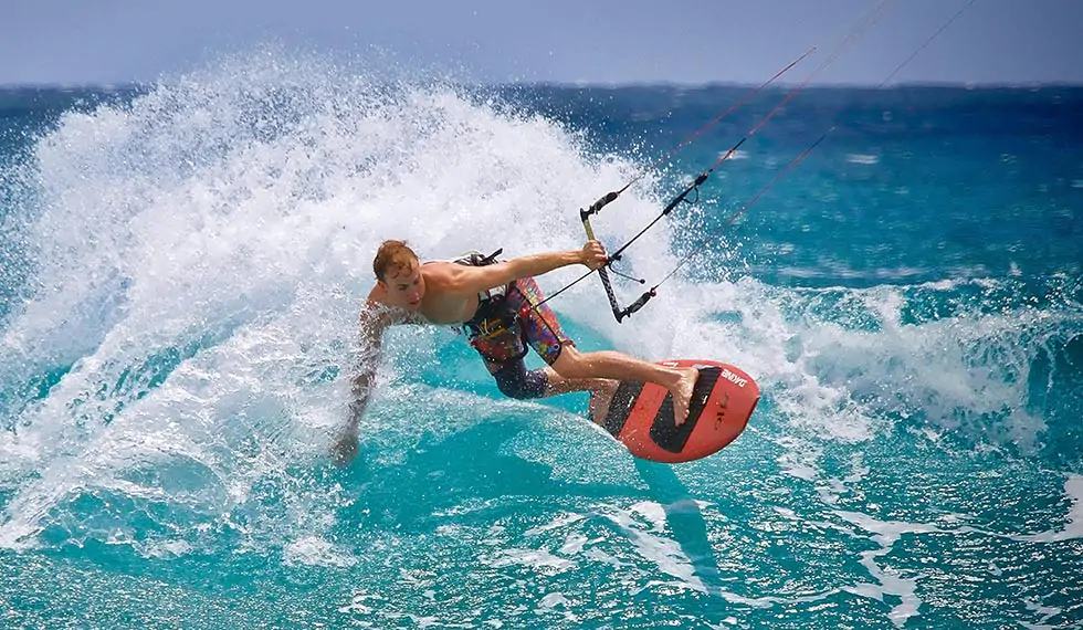 Kitesurfer throwing spray off a wave in Cabarete bay, Dominican Republic